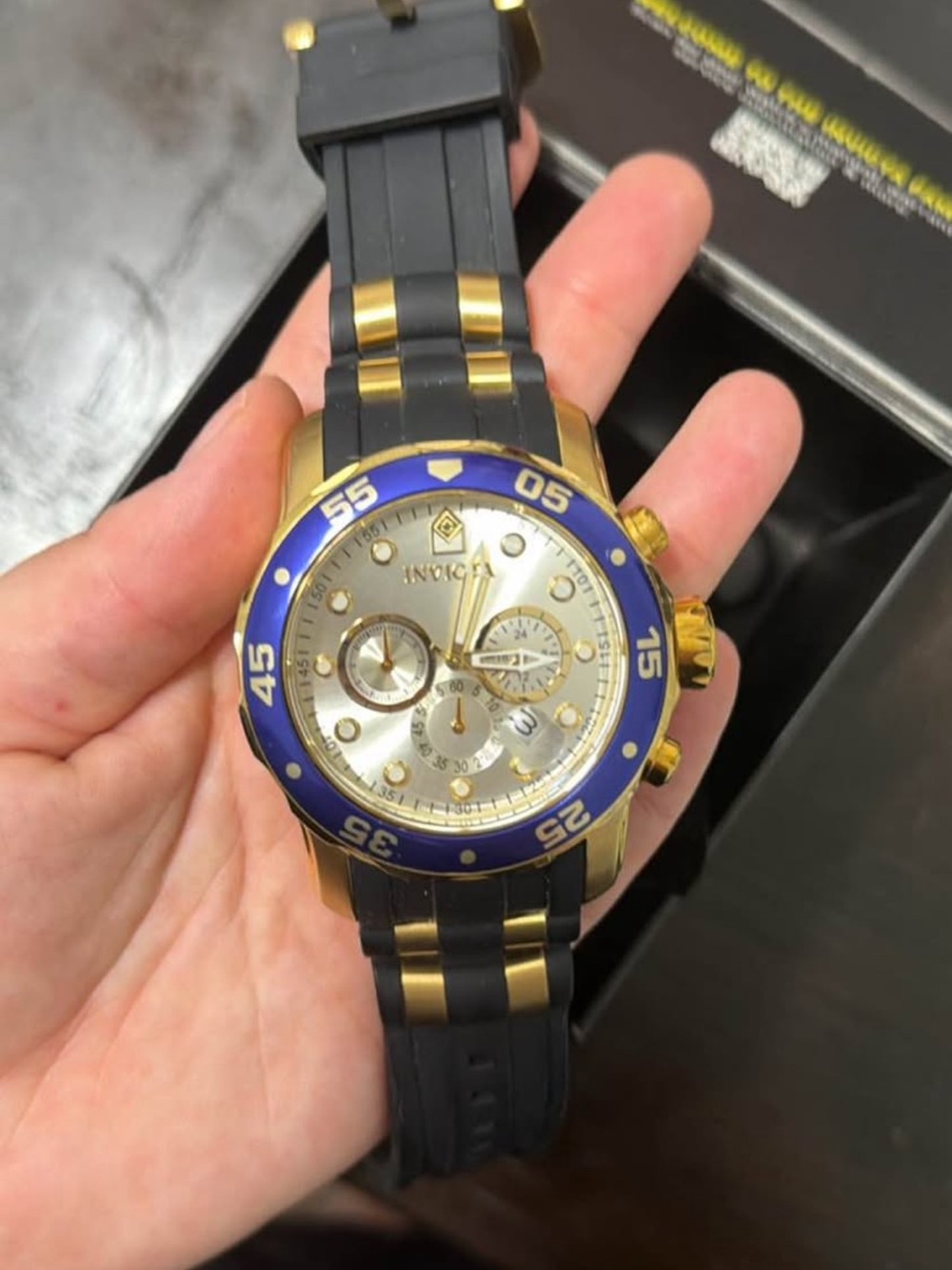 Invicta Gold Tone Watch with Blue Bezel and Black Strap